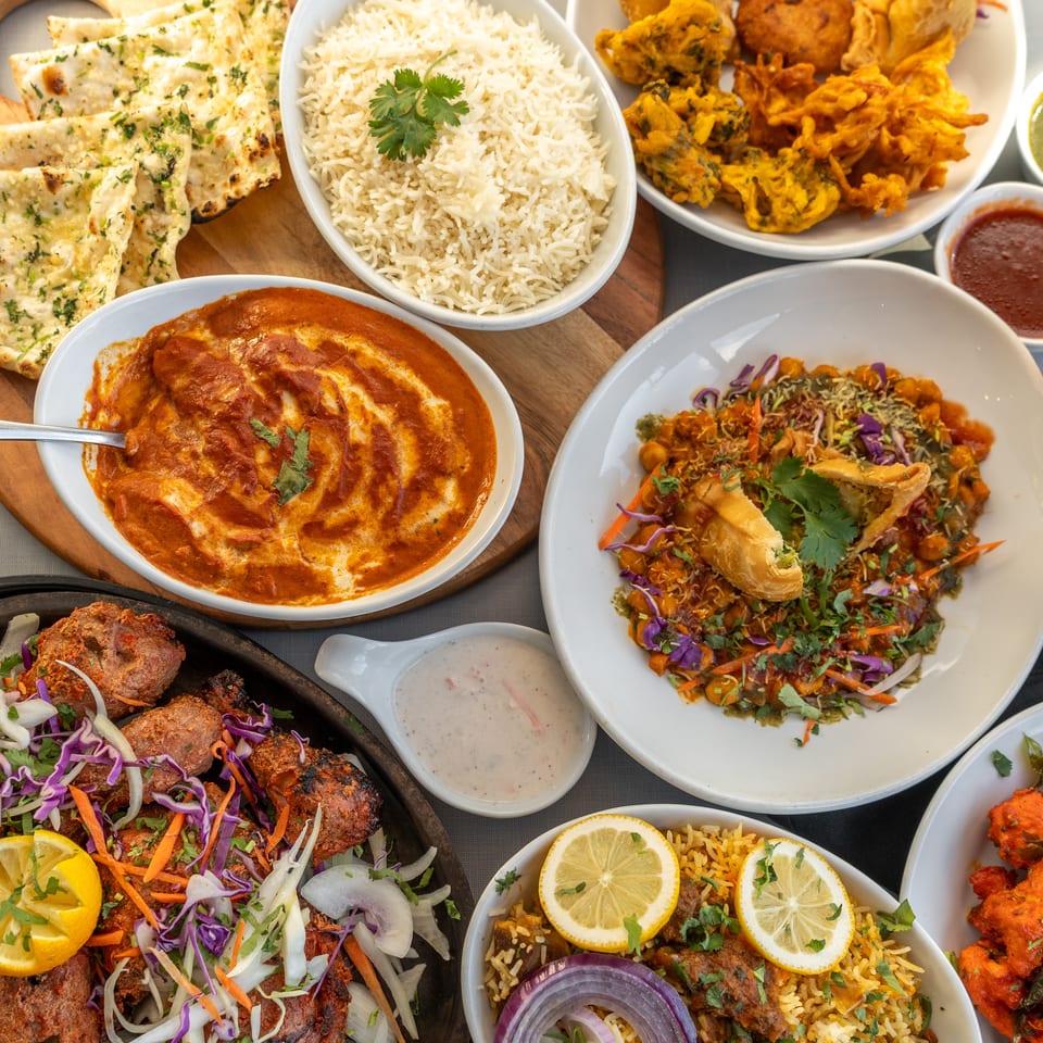 Indian dishes with rice, naan, and chutneys